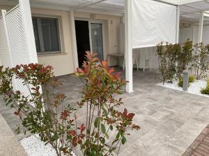 a patio with some plants and a building at NEW Apartment Diana Ovest in Bibione