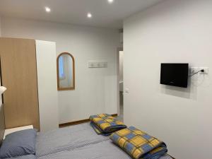 ein Schlafzimmer mit einem Bett und einem TV an der Wand in der Unterkunft NEW Apartment Diana Ovest in Bibione