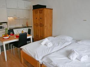 two beds in a room with a desk and a kitchen at Apartment Rosablanche D32 by Interhome in Siviez +13 photos