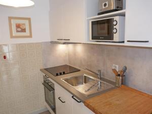 a kitchen with a sink and a microwave at Apartment Nid d'aigle E1 by Interhome in Nendaz