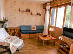 ein Wohnzimmer mit einem blauen Sofa und einem TV in der Unterkunft Apartment Chaedoz 43 by Interhome in Nendaz