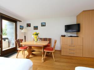 Habitación con mesa, sillas y TV. en Apartment Residence A-1 by Interhome, en Zermatt