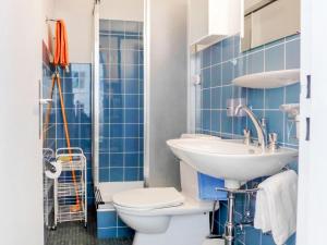 ツェルマットにあるミルハウス エ ツェルマットの青いタイル張りのバスルーム(トイレ、シンク付)