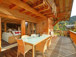 a wooden patio with a table and chairs on a deck at Chalet Khamariah by Interhome in Villars-sur-Ollon
