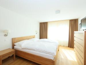 1 dormitorio con 1 cama con sábanas blancas y ventana en Apartment Zur Matte B-4 by Interhome, en Zermatt
