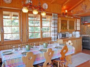 eine Küche mit einem Tisch, Stühlen und Fenstern in der Unterkunft Chalet Dejo A Dzeu by Interhome in Nendaz
