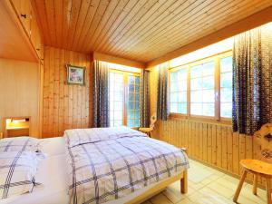 ein Schlafzimmer mit einem Bett in einem Zimmer mit Fenstern in der Unterkunft Chalet Dejo A Dzeu by Interhome in Nendaz