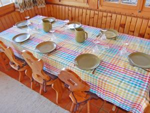 a table with chairs and plates and wine glasses at Chalet Dejo A Dzeu by Interhome in Nendaz