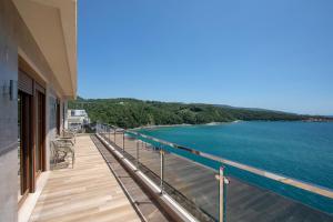 a balcony of a house with a view of the water at Royal Bay in Dobra Voda