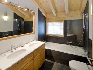 a bathroom with two sinks and a tub and a toilet at Apartment Zur Matte B-11 by Interhome in Zermatt