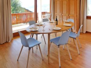 ヴィラール・シュル・オロンにあるApartment Hyacinthe 11 by Interhomeの木製テーブル(椅子付)、ワイン1本