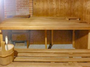 una mesa de madera en una sauna con un cubo de basura en Apartment Christina 305 by Interhome, en Crans-Montana