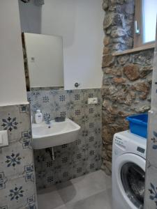 a bathroom with a sink and a washing machine at Cortile delle mura in Cefalù +27 photos