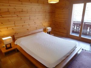 a bedroom with a white bed in a wooden wall at Apartment Rhodonite 33 by Interhome in Villars-sur-Ollon +14 photos
