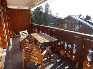 a wooden table and chairs on a balcony at Apartment Rhodonite 33 by Interhome in Villars-sur-Ollon