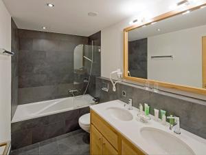 a bathroom with a sink and a toilet and a mirror at Apartment Zur Matte B-8 by Interhome in Zermatt