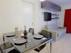 a dining room with a table with wine glasses and a couch at Apartment Andrea B15 by Interhome in Vermala