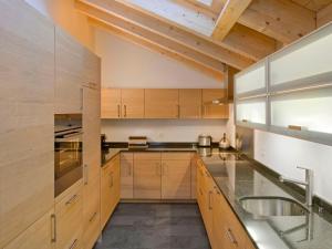 duża kuchnia z drewnianymi szafkami i zlewem w obiekcie Apartment Zur Matte B-9 by Interhome w mieście Zermatt