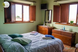 una camera con letto, lavandino e finestre di Antiche Vie B&B a Serramazzoni