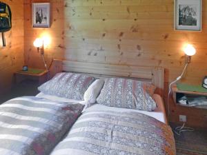 sypialnia z 2 łóżkami w drewnianej ścianie w obiekcie Chalet Allegra by Interhome w mieście Grächen