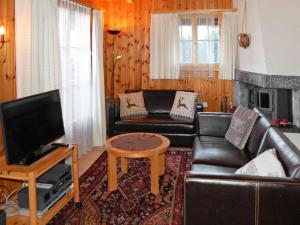 sala de estar con muebles de cuero y TV en Chalet Magicien by Interhome, en Nendaz