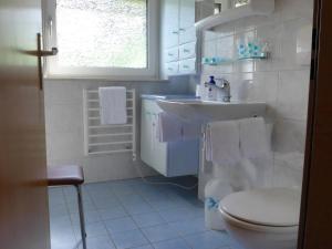 a white bathroom with a sink and a toilet at Apartment Luchre by Interhome in Zermatt