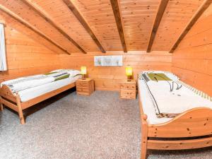 グレヘンにあるApartment Kelly by Interhomeのログキャビン内のベッド2台が備わる部屋です。