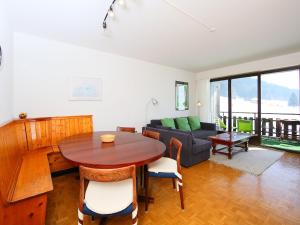 ein Wohnzimmer mit einem Tisch und einem Sofa in der Unterkunft Apartment Marignac 33 by Interhome in Villars-sur-Ollon