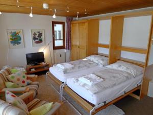 1 dormitorio con 2 literas y 1 silla en Apartment Aragon N103 by Interhome, en Fiesch