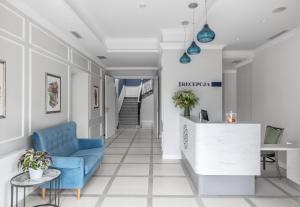 a lobby with a blue chair and a reception desk at Merci Boutique Hotel in Kraków