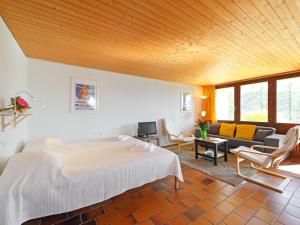 Un dormitorio con una cama y una sala de estar. en Apartment Les Beluardes Bl- 151-2 by Interhome, en Taveyannaz