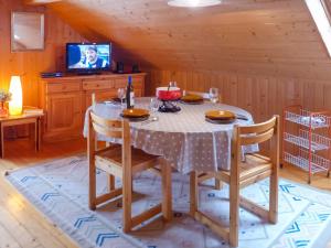 Apartment Les Fougères by Interhome في Les Rasses: غرفة طعام مع طاولة وكراسي وتلفزيون