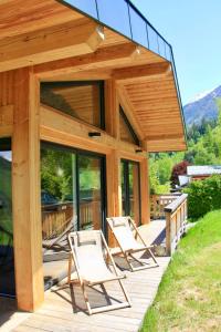 eine Gruppe von Stühlen auf einer Holzterrasse in der Unterkunft Modern Chalet With Garden Chamonix in Chamonix-Mont-Blanc