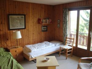 a bedroom with a bed and a chair and a window at Chalet L'Alpage by Interhome in Ovronnaz