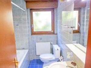 a bathroom with a toilet and a sink and a window at Apartment Terrasse Des Alpes 3008 by Interhome in Vermala