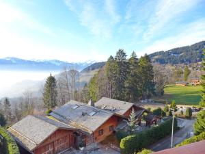 une vue aérienne sur une maison avec des montagnes en arrière-plan dans l'établissement Apartment Les Girolles B14 by Interhome, à Villars-sur-Ollon