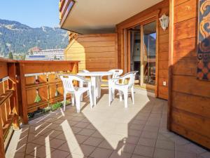 een patio met een tafel en stoelen op een balkon bij Apartment Résidence Le Bristol 14 by Interhome in Villars-sur-Ollon