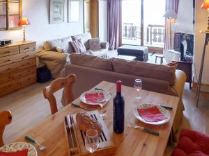 een woonkamer met een bank en een tafel met wijnglazen bij Apartment Résidence Le Bristol 14 by Interhome in Villars-sur-Ollon