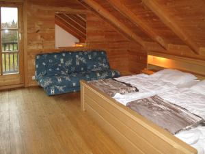 a bedroom with a bed and a couch in a cabin at Holiday Home Ilztal by Interhome in Allmunzen