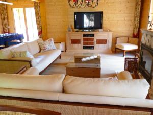 ein Wohnzimmer mit Sofas und einem Flachbild-TV in der Unterkunft Chalet Voltaire by Interhome in Ovronnaz