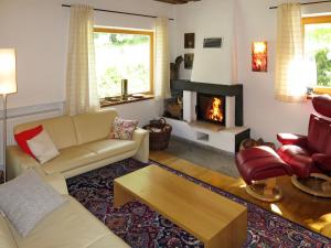 Una sala de estar con un sofá y una chimenea. en Holiday Home Kaiserhäusl by Interhome, en Bischofsreut
