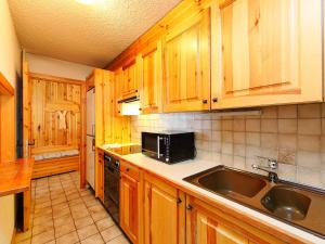 uma cozinha com armários de madeira e um lavatório em Apartment Hyacinthe 2 by Interhome em Villars-sur-Ollon