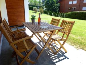 una mesa de madera con 4 sillas y una botella de vino en Apartment Hyacinthe 2 by Interhome, en Villars-sur-Ollon