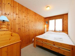 ヴィラール・シュル・オロンにあるApartment Hyacinthe 2 by Interhomeの木製の壁のベッドルーム1室(ベッド1台付)