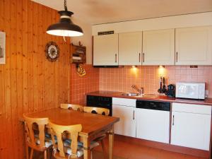 eine Küche mit einem Holztisch und weißen Schränken in der Unterkunft Apartment Beausoleil H by Interhome in Veysonnaz