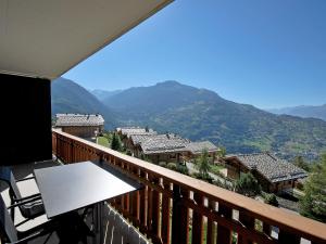 balcón con mesa y vistas a la montaña en Apartment Beausoleil H by Interhome, en Veysonnaz