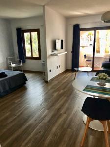 a room with a bed and a table and a living room at Apartamentos El Bergantin Menorca Club in Fornells