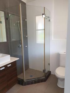 a bathroom with a shower and a toilet at Reef Terraces on St Crispins - Villa 2 in Port Douglas +9 photos
