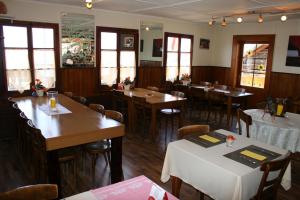 a dining room with tables and chairs and windows at B&B Café de la Poste in Agettes