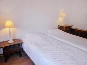 a bedroom with a bed and two night stands with lamps at Apartment Villars Soleil A27 by Interhome in Villars-sur-Ollon
